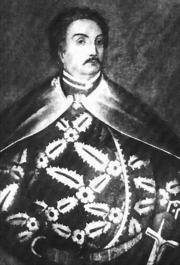 Schwarzes und weißes Foto von Papst Johannes Paul II. in Priesterrobe, der eine schwarze Robe mit weißem Kragen und Manschetten trägt und die Hände verschränkt, mit ernstem Gesichtsausdruck und direktem Blick.