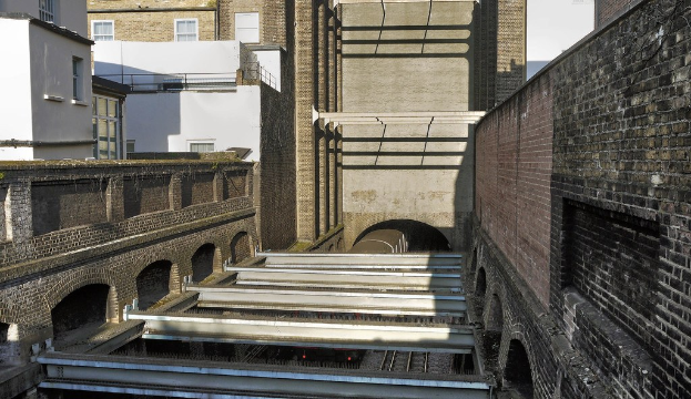 Gebäude mit einem Tunnel, durch den ein Zug fährt.