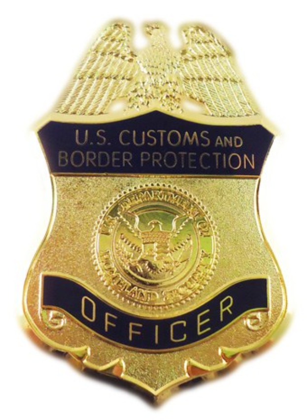 Goldene Abzeichen mit der Aufschrift "U.S. Customs and Border Protection Officer" auf weißem Hintergrund.