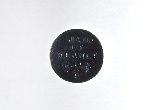 Schwarze Münze mit dem Text "Lügner de France" auf einem weißen Hintergrund.