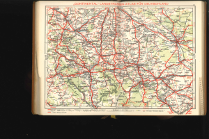 Offenes Buch zeigt eine detaillierte Karte von Deutschlands Straßen und Autobahnen auf einem schwarzen Hintergrund.