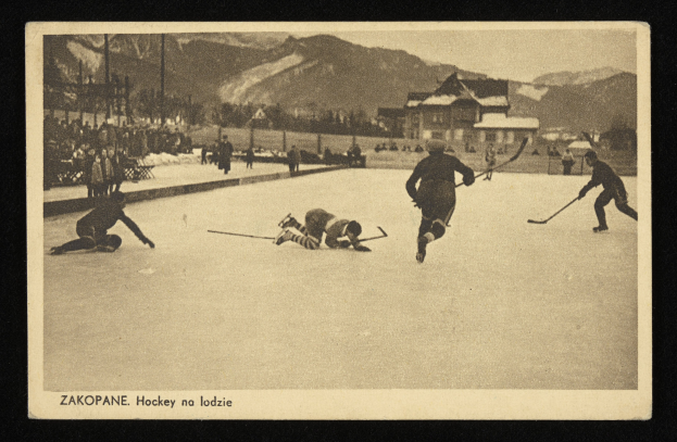 Schwarzes und weißes Foto von Menschen, die Hockey auf einem Eisplatz spielen, umgeben von Gebäuden, Bäumen, Pfählen und Bergen, mit Text unten.