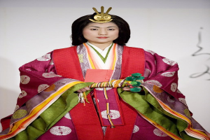 Eine Frau in einem traditionellen japanischen Kimono steht selbstbewusst auf einem Laufsteg und trägt ein leuchtend rotes und grünes Kimono mit aufwändigen Mustern und einem ordentlich zurückgebundenen Dutt.