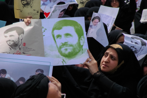 Eine Gruppe iranischer Frauen in schwarzer Kleidung, einige mit Brille, hält Fotos des Präsidenten Mahmoud Ahmadinejad während einer Demonstration in Tehran hoch.