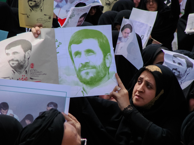 Eine Gruppe iranischer Frauen in schwarzer Kleidung, einige mit Brille, hält Fotos des Präsidenten Mahmoud Ahmadinejad während einer Demonstration in Tehran hoch.