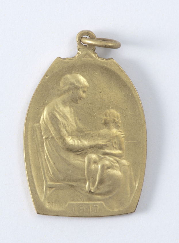 Goldmedaille mit einer Reliefdarstellung einer Frau in einem weißen Kleid mit einem Dutt, die ein Kind hält, beide schauen sich zärtlich an, beschriftet mit 'Mutter und Kind' in Kursivschrift.