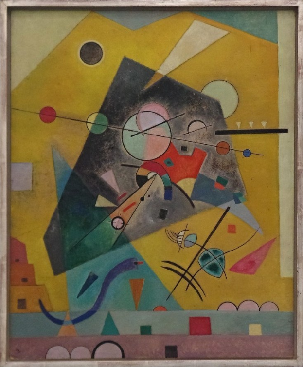 Ein gerahmtes Gemälde von Wasily Kandinsky hängt an einer Wand in einem Raum.