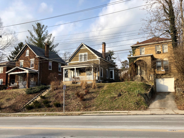 Eine Reihe von Häusern mit verschiedenen architektonischen Merkmalen und Grünflächen, unter einem bewölkten Himmel, eines der 10 teuersten Häuser zum Verkauf in Detroit, Michigan.