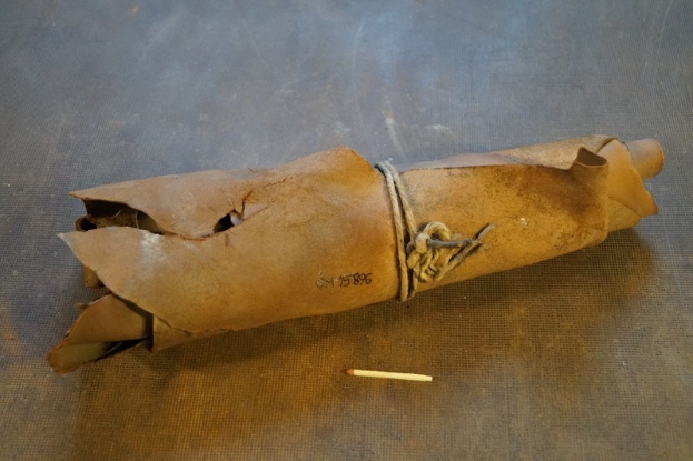 Papiertüte in Form einer Granate, mit Seil verschnürt, mit einer Zigarette daneben auf einem Tisch.