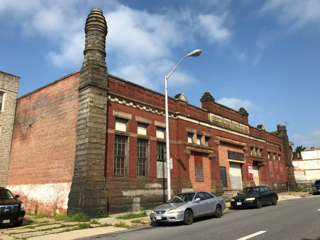 Altes Backsteingebäude mit seitlichem Schornstein, identifiziert als ehemalige St. Louis Fire Station, umgeben von Straßeninfrastruktur, Fahrzeugen, Bäumen und einem bewölkten Himmel.
