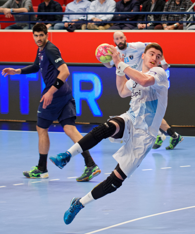 Eine Gruppe von Männern, die auf einem Platz Handball spielen, mit einem Ball in der Mitte, Zuschauern im Hintergrund und einer Tafel mit "Futsal-Weltmeisterschaft 2019" und den Tagen des Ereignisses.